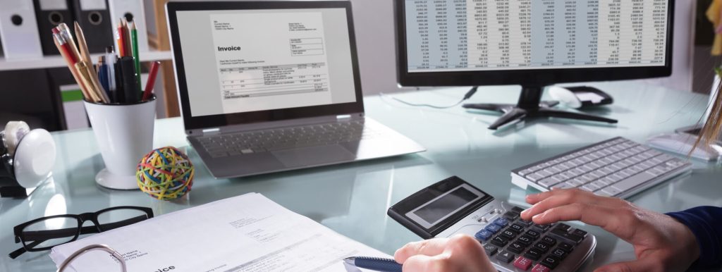 Man checking invoice against bank statement while doing bookkeeping