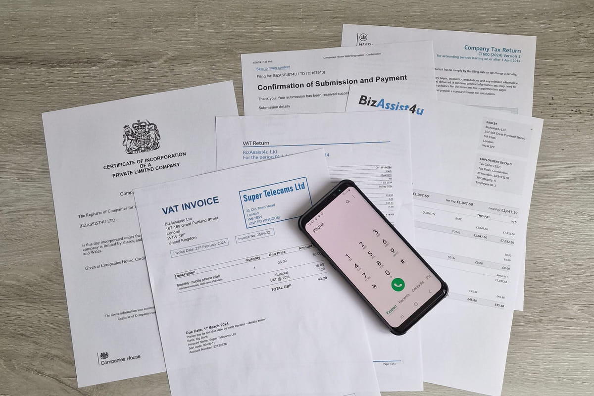 Pile of statutory filing documents, payslip and mobile phone